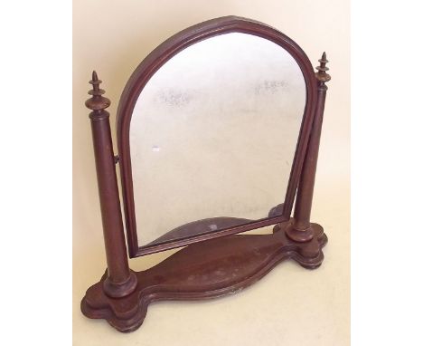 A Victorian mahogany framed oval mirror on turned supports