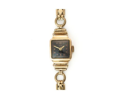 A TITUS GOLD SHAPED RECTANGULAR CASED LADY'S WRISTWATCHThe signed square black dial with Arabic numerals, detailed to the cas