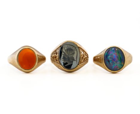 THREE 9CT GOLD RINGS (3)Comprising; an oval cornelian signet ring, size S½, a haematite intaglio ring, with pierced decoratio