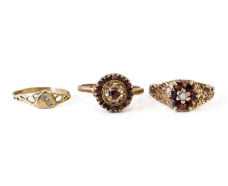 THREE 9CT GOLD RINGS (3)Comprising; a garnet and opal seven stone cluster ring, London 1972, ring size O, a 9ct gold and garn