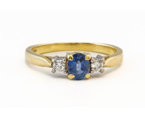 AN SAPPHIRE AND DIAMOND THREE STONE RINGClaw set with a central oval mixed cut sapphire, flanked either side by a round brill