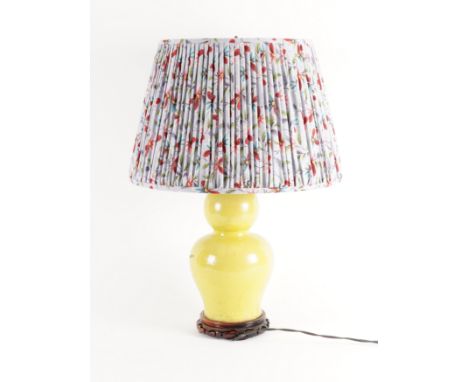 AN ACID YELLOW GLAZED CERAMIC LAMP20th Century
Of double gourd form, with pleated purple floral shade, 66cm high including sh