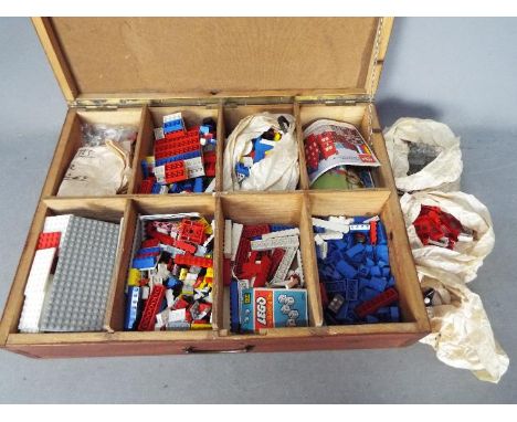 LEGO - A wooden box containing a large quantity of loose vintage Lego bricks and parts. The wooden box measures approximately