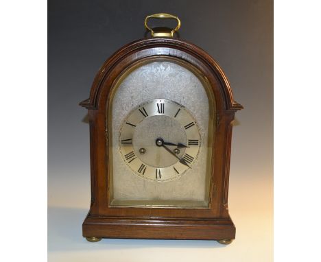 An Edwardian mahogany bracket clock, 16cm arched silvered dial with chapter ring of Roman numerals, engraved with scrolling f