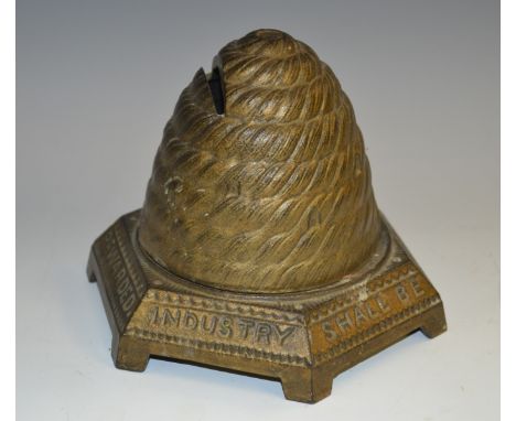 A Victorian cast iron novelty money box, cast as a bee skep, the hexagonal base inscribed Industry Shall Be Rewarded, bracket