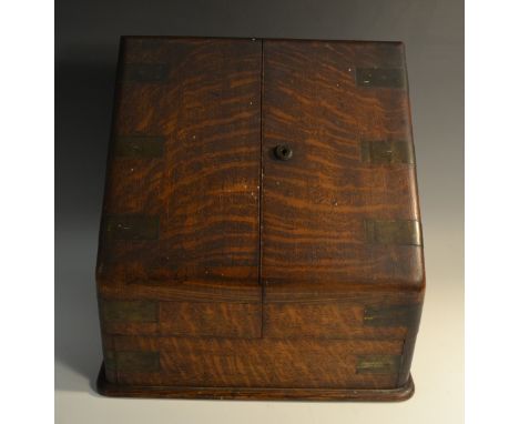 A Victorian 'Campaign' brass mounted oak slope fronted stationery cabinet, hinged twin-covers enclosing well and pen aperture