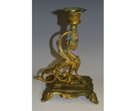 A 19th century gilt metal chamber stick, cast as a sphinx, hexagonal sconce, shaped rectangular base, acanthus feet, 18cm hig