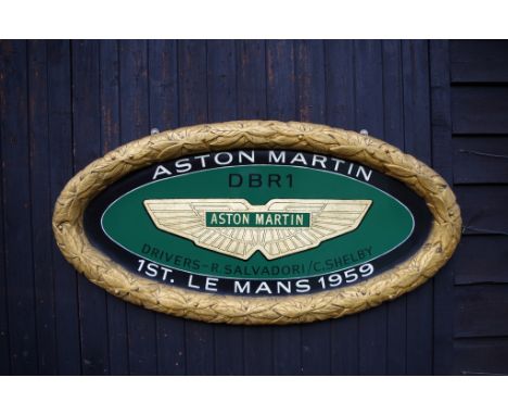 Raised laurel leaf framed hand painted oval wall sign. Celebrating Aston Martin's 1959 victory at Le Mans with the DBR1 drive