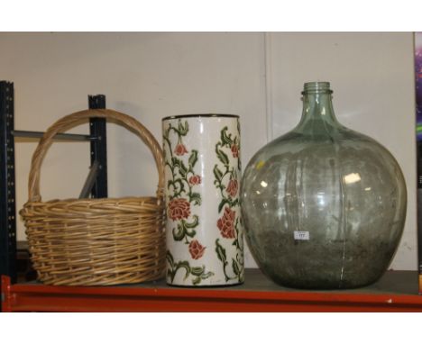 A LARGE GLASS CARBOY, CERAMIC STICK STAND PLUS A LARGE WICKER BASKET