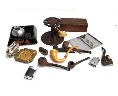 A vintage pipe rack with various pipes, two Ronson table lighters and two others, a cigarette case, a Bass ashtray, cigar hol