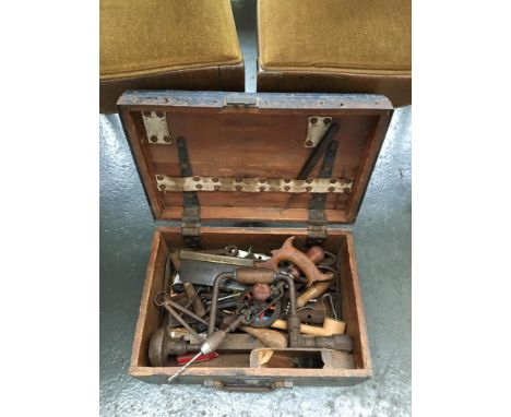 A wooden tool chest containing a collection of vintage tools 