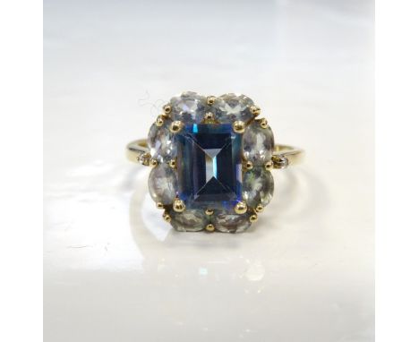 BLUE GEM SET CLUSTER RINGthe central emerald cut stone in surround of lighter blue stones, on nine carat gold shank, ring siz