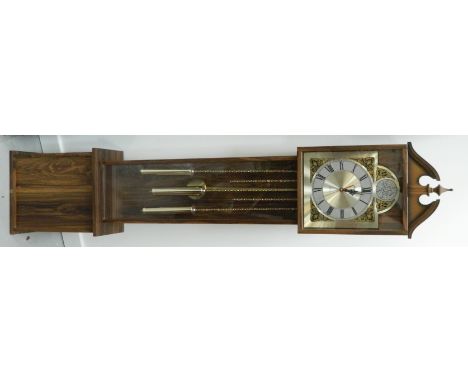 SIMULATED OAK QUARTZ LONGCASE CLOCKwith a broken swan neck pediment and urn finial above an arched dial with Roman numerals, 