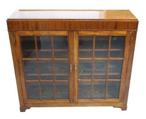 MAHOGANY BOOKCASEwith a pair of panelled glazed doors opening to reveal a shelved interior, standing on bracket feet, 108cm w
