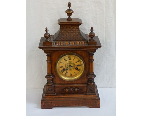 GERMAN WALNUT BRACKET CLOCKthe circular dial with Roman numerals, contained in a shaped case, 47cm high 