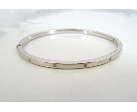 DIAMOND SET NINE CARAT WHITE GOLD BANGLEthe hinged bangle with five flush set diamonds, approximately 6.5 grams