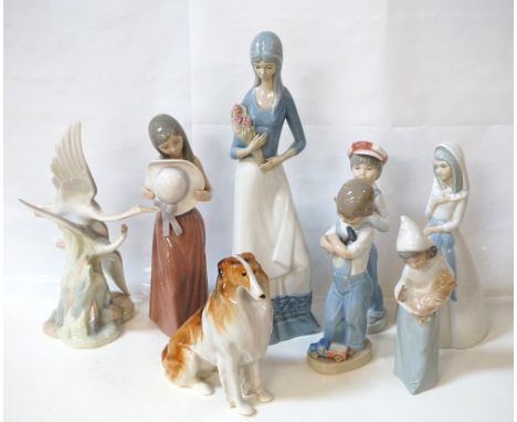 FOUR LLADRO PORCELAIN FIGUREScomprising a young girl holding her hat, 25cm high; a young boy with an accordion, 21.5cm high; 