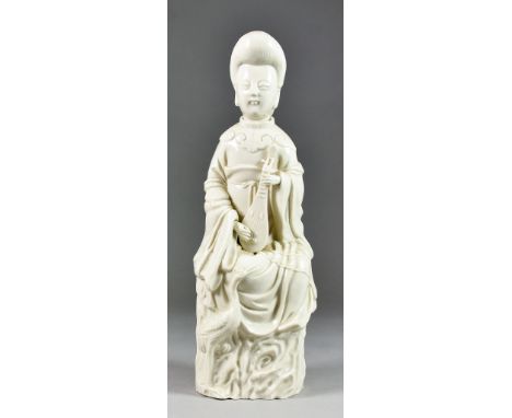 A Chinese Blanc de Chine Model of a Seated Female Figure Playing a Stringed Instrument, on naturalistic base, 14ins (35.5cm) 