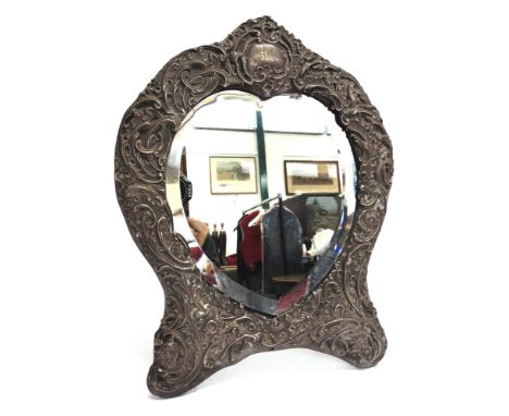 A HEART SHAPED EASEL BACK SILVER DRESSING TABLE MIRROR  by William Comyns, London 1908, with monogrammed cartouche to the arc