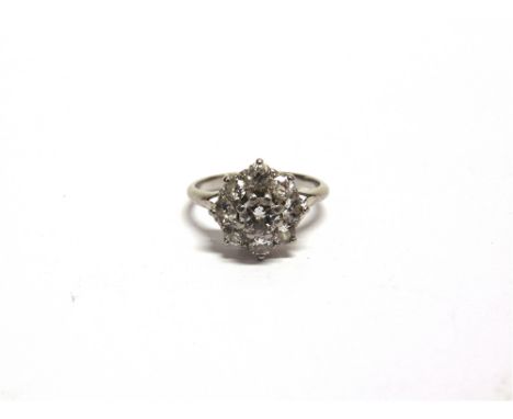 A NINE STONE DIAMOND CLUSTER RING the white mount stamped 'Plat', the central brilliant cut of approximately 0.5 carats, encl