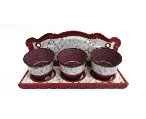 A SET OF THREE FRENCH ENAMEL PLANTERS IN HOLDER with gilt decoration, the planters 11cm diameter at top, the holder 39cm wide