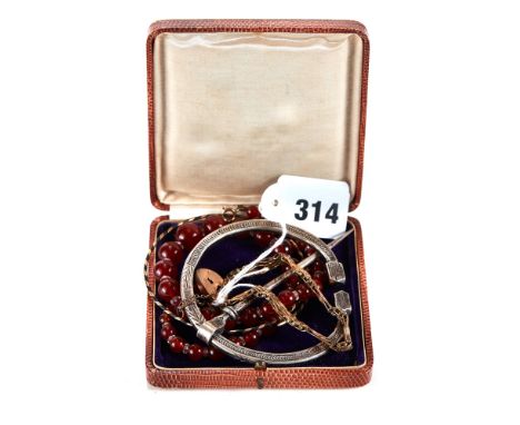 A GRADUATED STRING OF CORNELIAN BEADS, 15 1/2 ins long, a white metal PLAID style BROOCH/ORNAMENT, a yellow metal bound BRACE