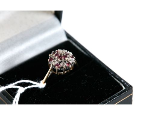 A 9CT YELLOW GOLD RUBY AND DIAMOND CLUSTER RING, size U, approximately 2.6 grams.   