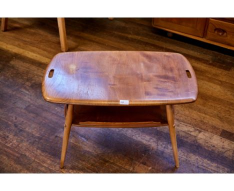 AN ERCOL LIGHT ELM "BUTLERS" COFFEE TABLE, the rounded end top with pierced hand-holds raised on outsplayed legs united by a 