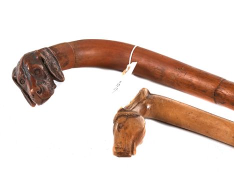 A LATE 19TH/EARLY 20TH CENTURY CARVED DOGS HEAD WALKING STICK and another with a horses head handle.  (2)   