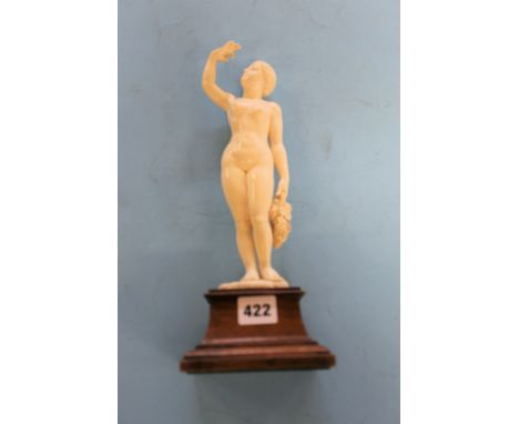 AN EARLY 20TH CENTURY ART DECO PERIOD CARVED IVORY FIGURE OF A NUDE LADY holding a bunch of grapes, on a wooden base, 12 1/2 