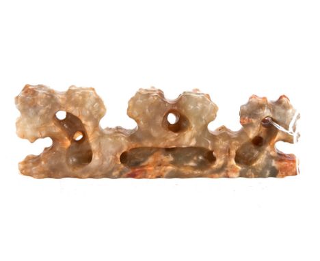 A CHINESE WHITE AND RUSSET JADE SCHOLARS BRUSH REST of mountainous rock form, 7 1/4 ins long.   