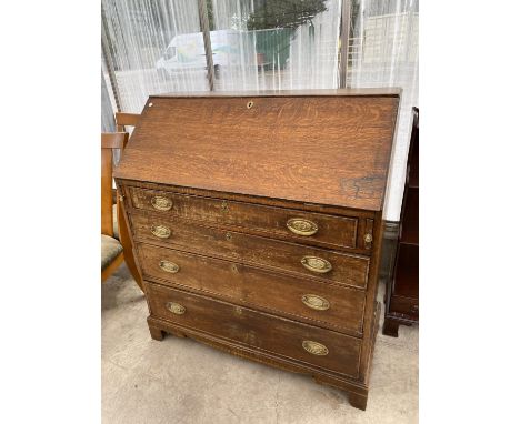 A GEORGIAN OAK BUREAU ON BRACKET FEET WITH FALL FRONT WITH FOUR DRAWERS HAVING BRASS HANDLES AND ESCUTCHEONS 