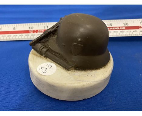 A VINTAGE PAPERWEIGHT WITH  GERMAN HELMET, LUGER AND GRENADE 