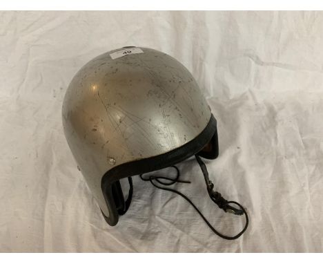 A VINTAGE SILVER COLOURED CRASH HAT 