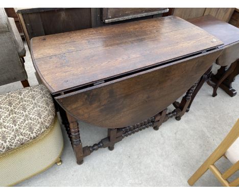 A DROP LEAF OAK DINING TABLE WITH BOBBIN TURNED SUPPORTS AND STRETCHER RAILS 