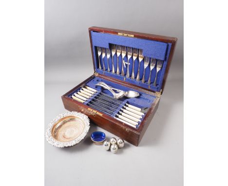 A silver plated part table canteen, in mahogany case, a 19th century Sheffield plate bottle coaster with scroll work rim, 7" 