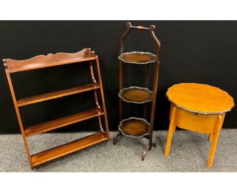 A mahogany three tier wall shelf, 75cm high x 56cm wide;  an Edwardian collapsible three tier cake stand, 93cm high;  a mid 2