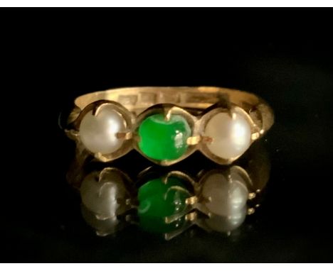 A Chinese jade and seed pearl ring, central deep green jade cabochon between two creamy white cultured pearls, 18ct gold shan