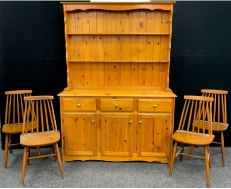 A pine dresser, two tier plate-rack top above three short drawers and three cupboard doors, 185.5cm high x 135cm wide x 46cm;
