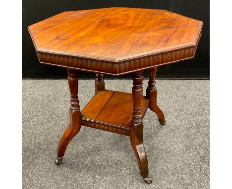 An Edwardian walnut octagonal occasional table, carved frieze, turned supports, with under-tier shelf, ceramic casters, 70cm 