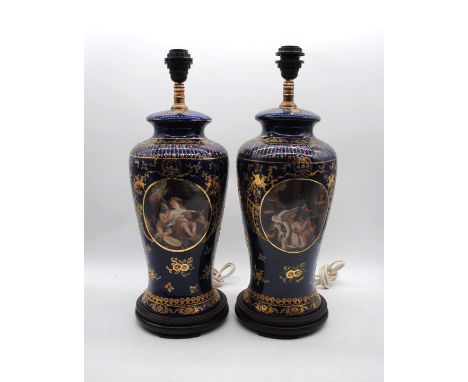 A pair of Classical style ceramic table lamp bases, of blue ground with gilded decoration and central panels depicting cherub