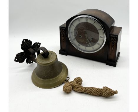 A brass bell on cast iron bracket along with an oak cased mantle clock 