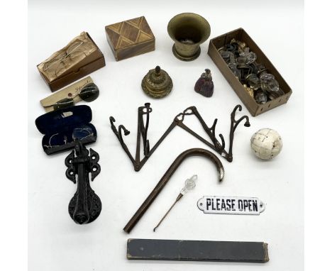 An assortment of items including antique folding set of coat hooks, ink well, lead figure, glasses door furniture, door knock