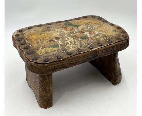A small folk art stool with leather top depicting a hunting scene
