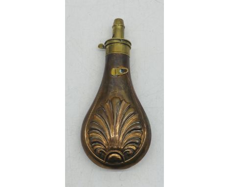 A vintage copper powder flask with embossed detailing 