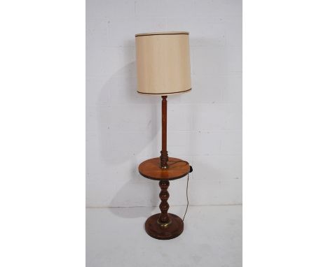 A wooden standard lamp with table base