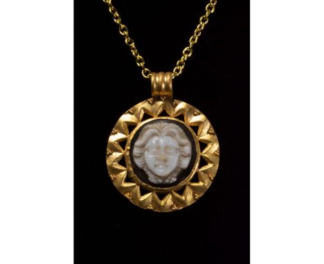 C. 100-300 AD. Roman. Gold pendant with circular, ribbed suspension loop and disk-shaped medallion with a white stone cameo s