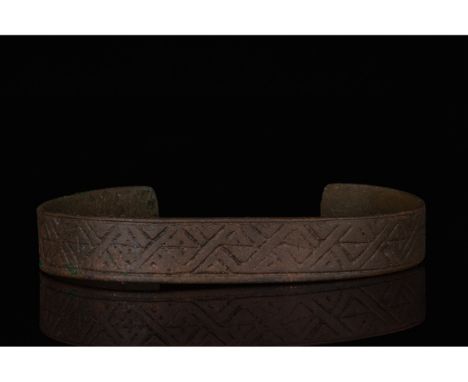 700-1100 AD, Viking Age. A bronze bracelet with rounded terminals and incised interlocking crosses. In Viking society, arm ri