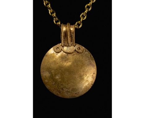 100-300 AD. Roman. Gold sun disk amulet comprising a rounded ribbed suspension loop and disc-shaped pendant with spiral decor