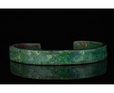 700-1100 AD, Viking Age. A heavy bronze bracelet with incised linear and punched dot decoration, and striations on the termin